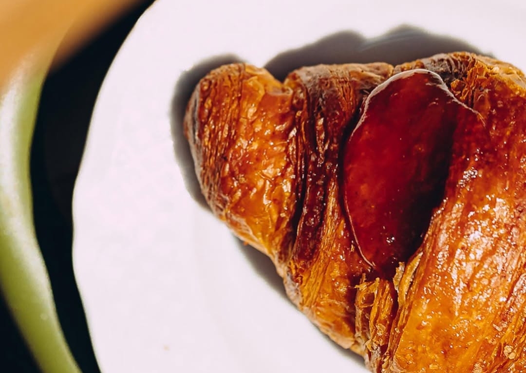 Cornetto con marmellata sul piatto della colazione
